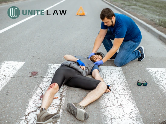 Personal injury lawyer helping a bicyclist after a bicycle accident and fall on a city street